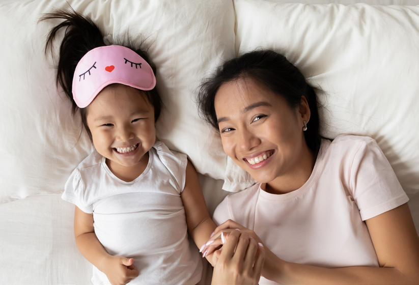 Smiling mum and daughter laying down