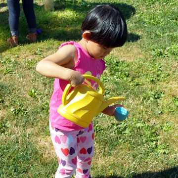 Little girl pouring water into a teacup